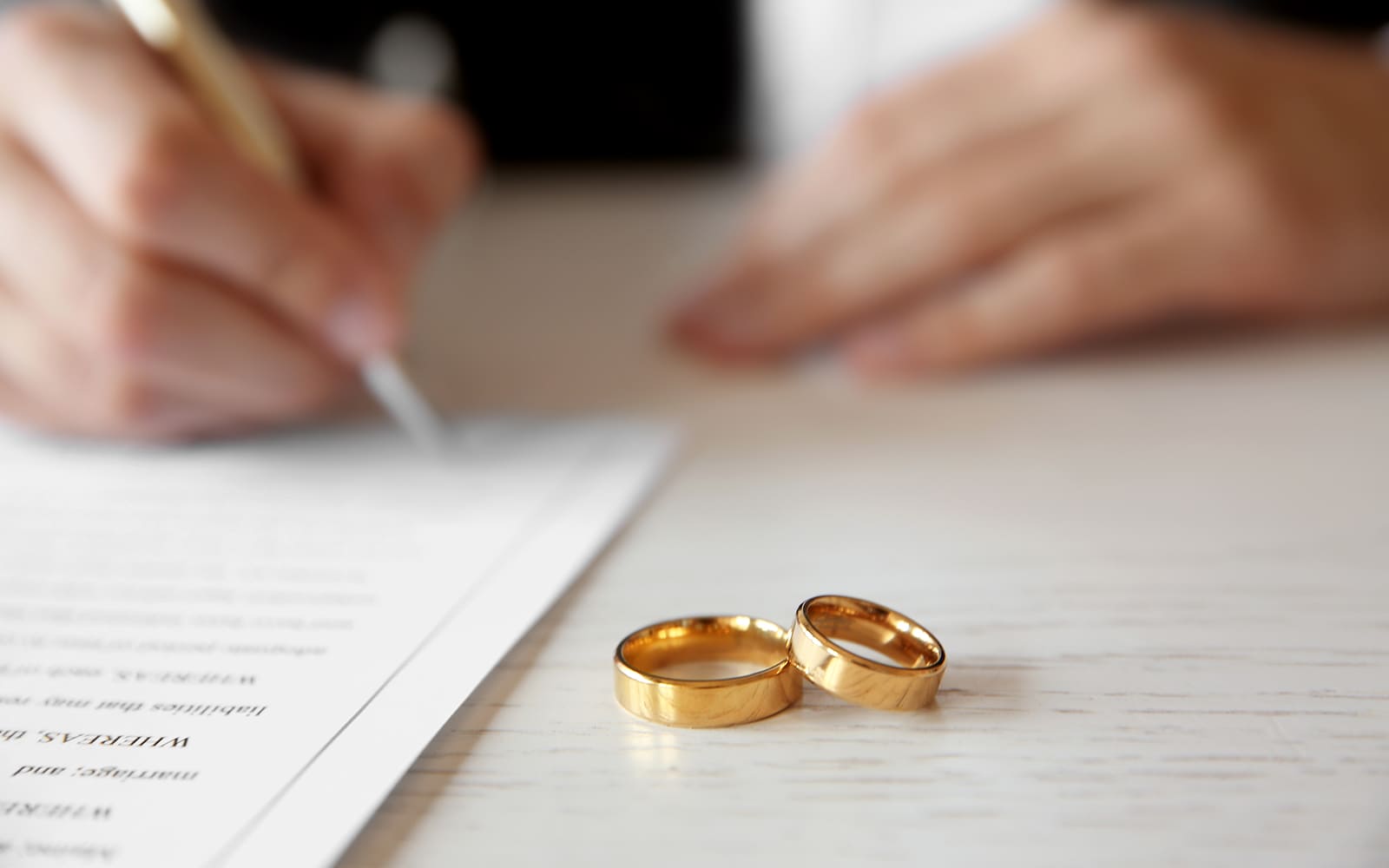 A married person signing a postnuptial agreement